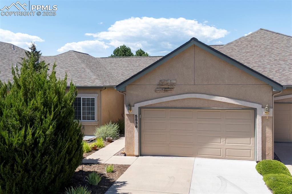 Image 2 of 42: View of front of house with roof with shingles, a garage, driveway, and stu