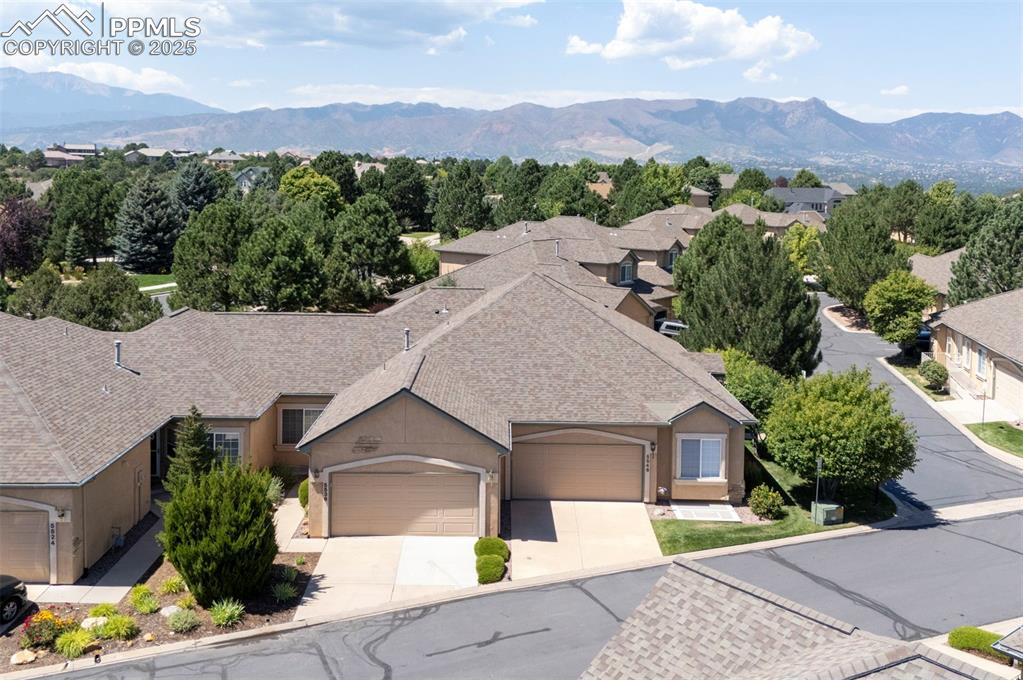 Image 4 of 42: Aerial view of property and surrounding area with a mountainous background