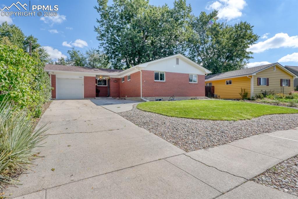 Caption: Ranch-style home with brick siding, a front lawn, a garage, and concrete driveway