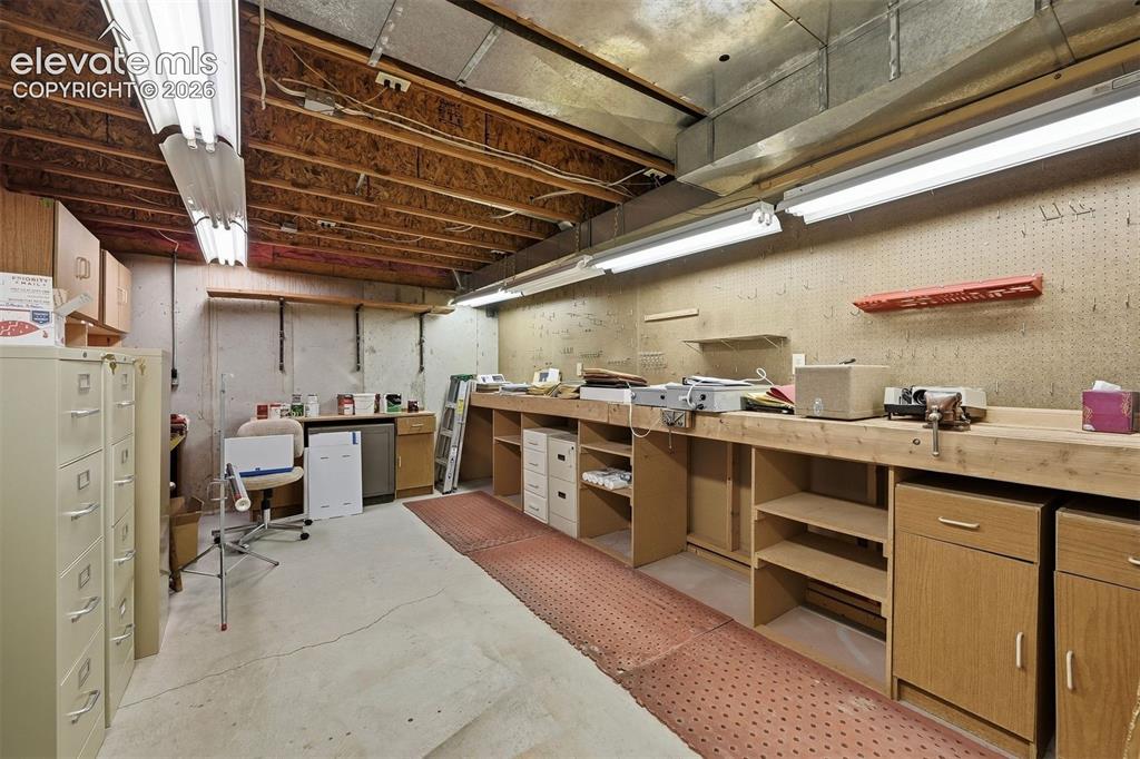 Image 28 of 40: Unfinished mechanical room with shop facilities.