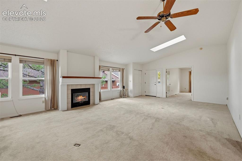 Image 3 of 40: Vaulted living room with fireplace looking south towards a fourth bedroom w