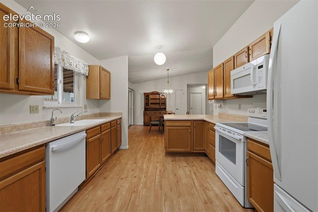 Image 5 of 40: Kitchen looking to garage. Newer appliances.