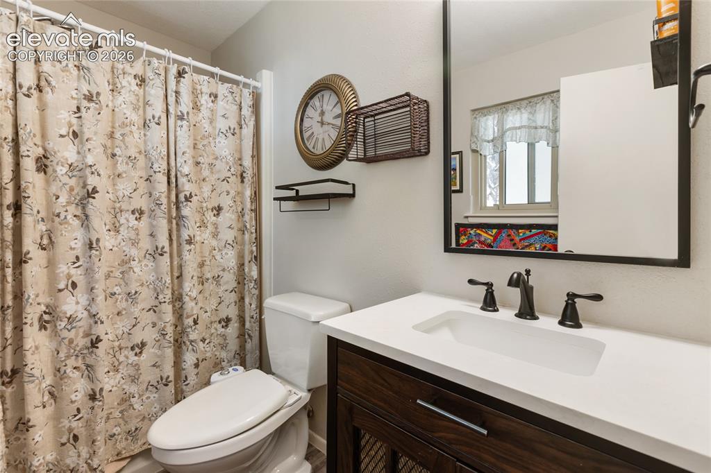 Image 31 of 39: White countertop with an integrated rectangular sink, bronze-finish faucet,