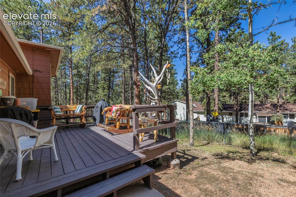 Image 36 of 39: Expansive outdoor deck with composite decking and wood railings, surrounded