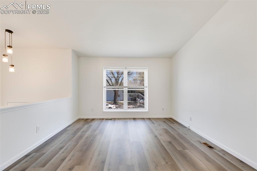 Image 5 of 32: Empty room with baseboards, visible vents, and wood finished floors