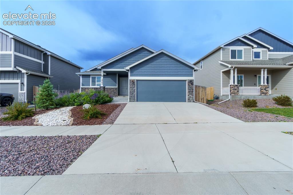 Image 1 of 27: Single-story residence featuring a blue siding exterior, stone veneer accen