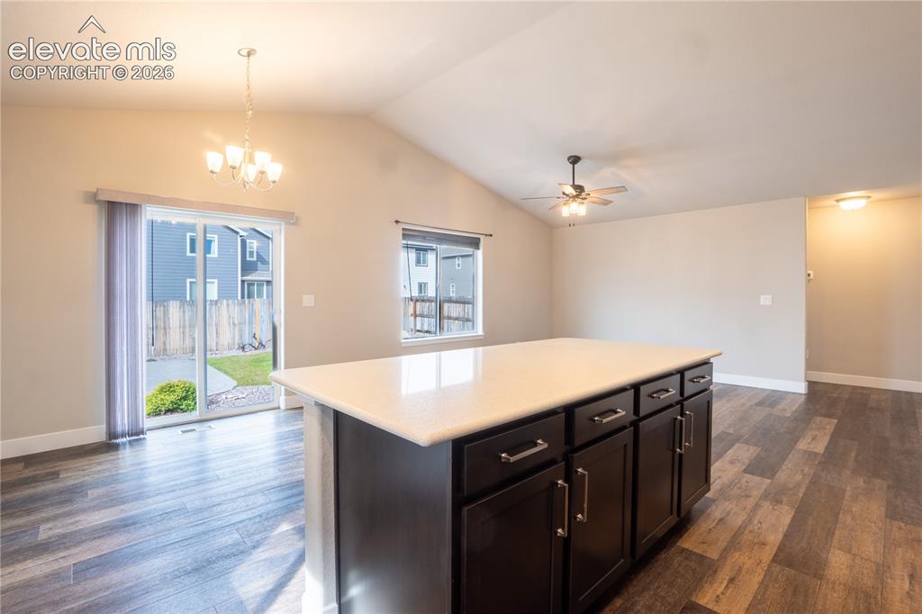 Image 11 of 27: Vaulted ceilings, wood-finish flooring, and a kitchen island with storage