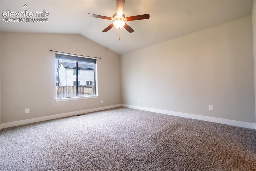 Image 13 of 27: Vaulted ceiling room featuring a ceiling fan with integrated lighting, a la