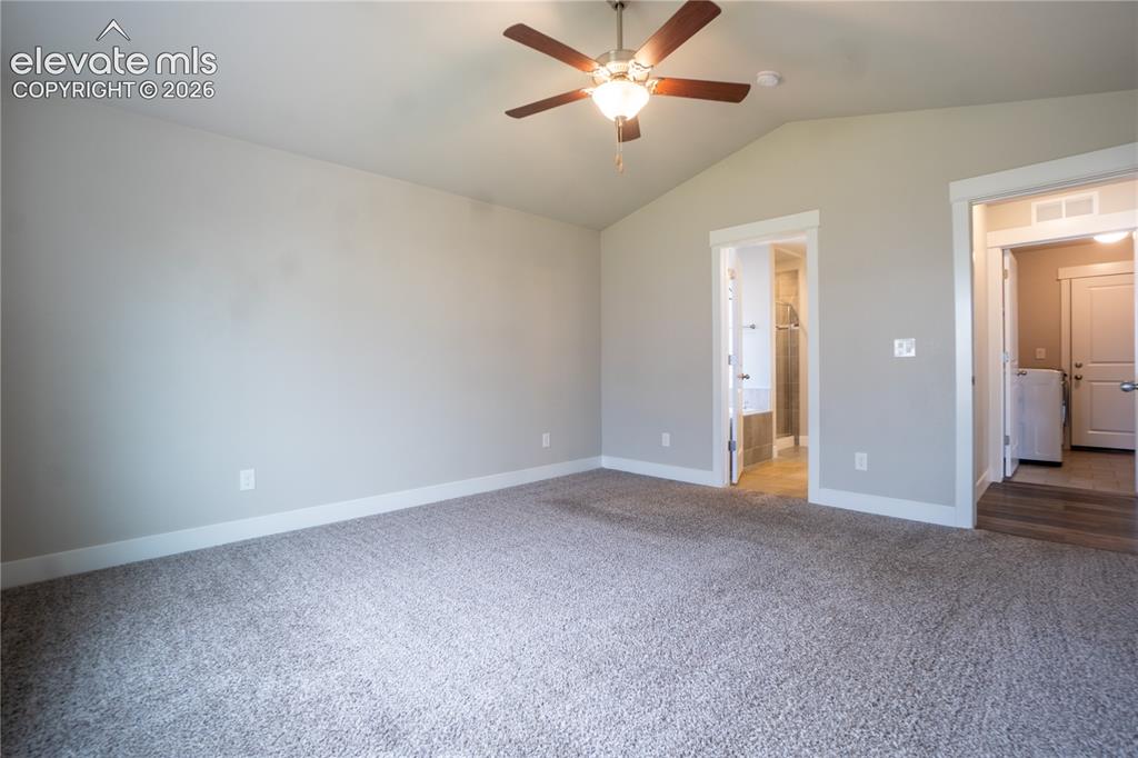 Image 14 of 27: Vaulted ceiling with a ceiling fan, plush carpet flooring, and neutral wall