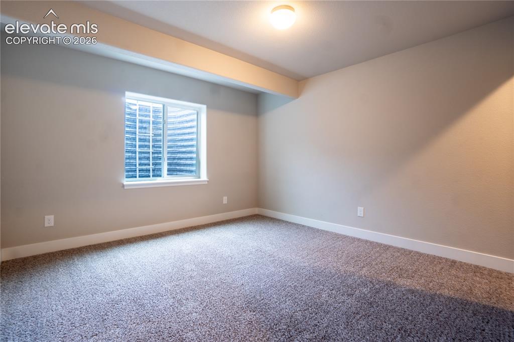 Image 20 of 27: Carpeted room with a rectangular window, light neutral wall paint, white tr
