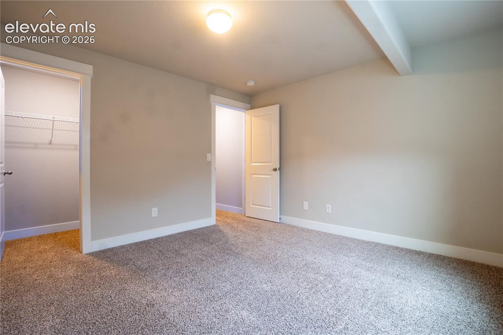 Image 21 of 27: Carpeted room with neutral wall paint and white trim