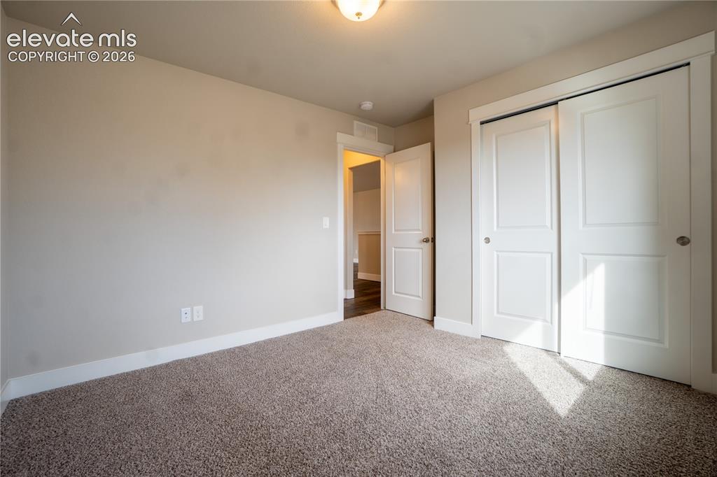 Image 6 of 27: Neutral tone walls, carpet flooring, flush mount ceiling light, and white p