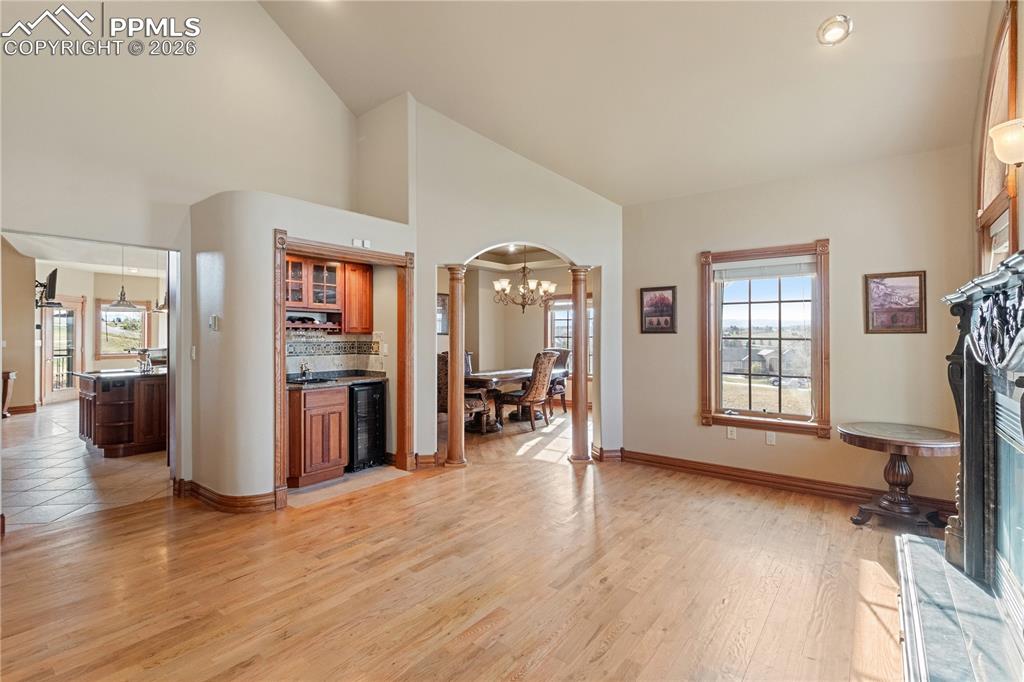 Image 11 of 50: Living room to right of entryway with wet bar, looking into dining room and