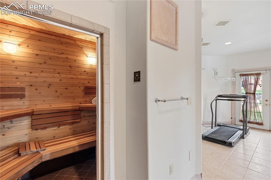 Image 40 of 50: Workout room in basement with sauna and shower
