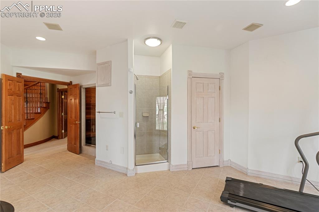 Image 41 of 50: Workout room in basement with sauna and shower