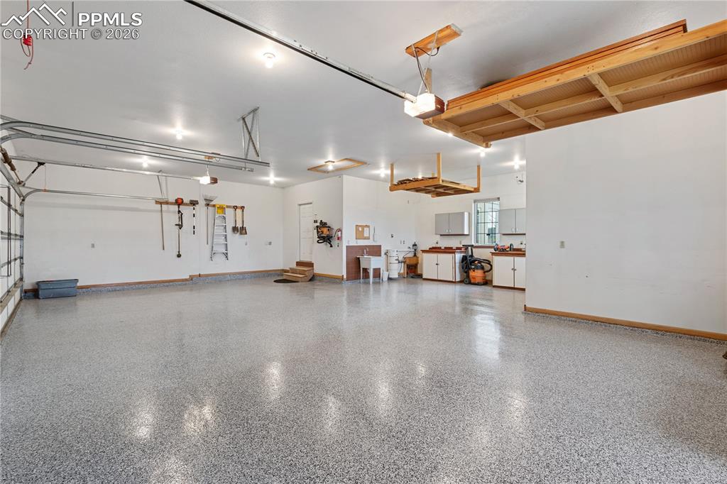 Image 43 of 50: 4 car garage with extra storage or work space, newly epoxied floors.