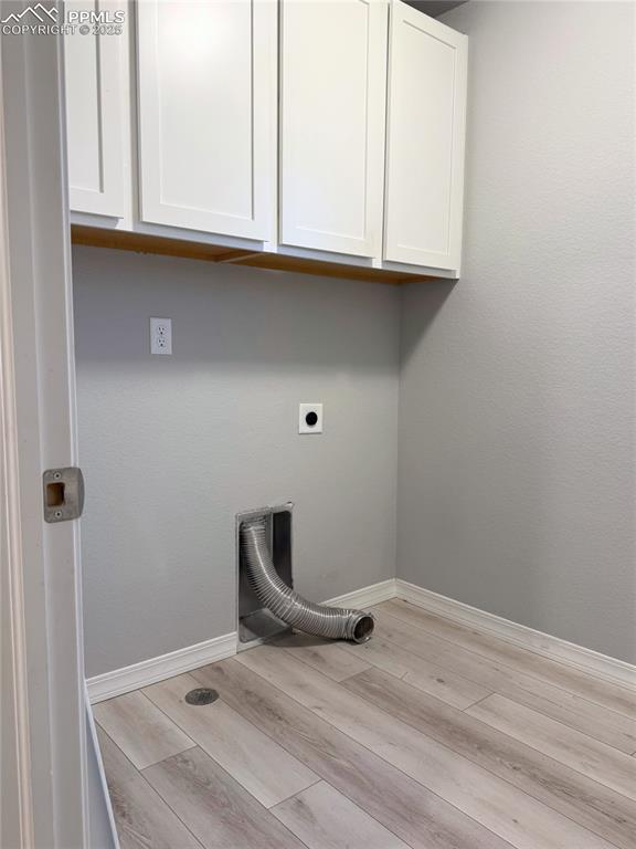 Image 13 of 14: Laundry room featuring light wood-style flooring, cabinet space, and electr