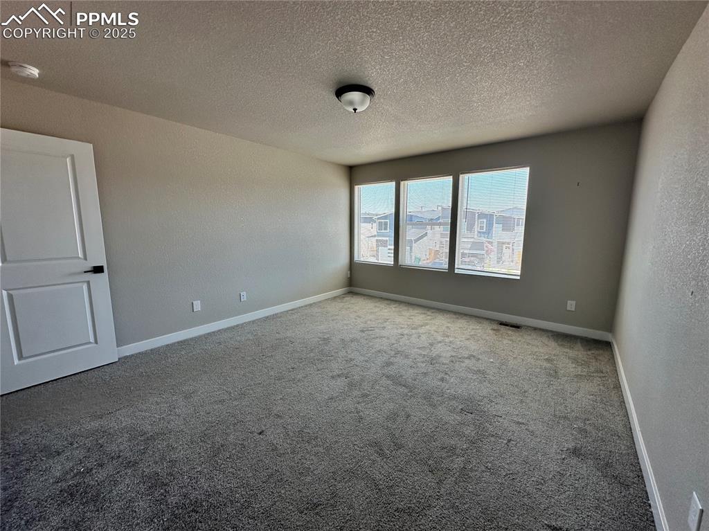 Image 14 of 19: Carpeted spare room with a textured ceiling and a smoke detector