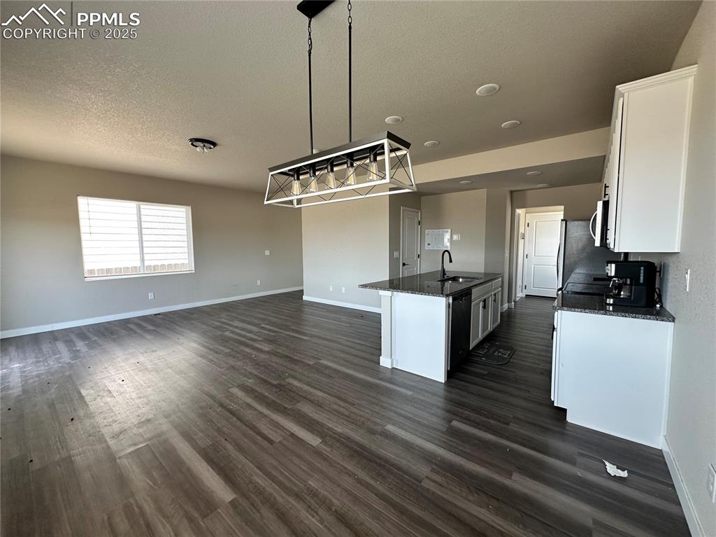 Image 3 of 19: Kitchen with white cabinetry, a textured ceiling, dark wood-type flooring,