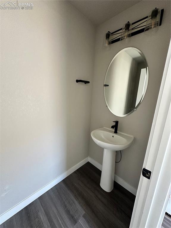 Image 8 of 19: Bathroom featuring wood finished floors and baseboards