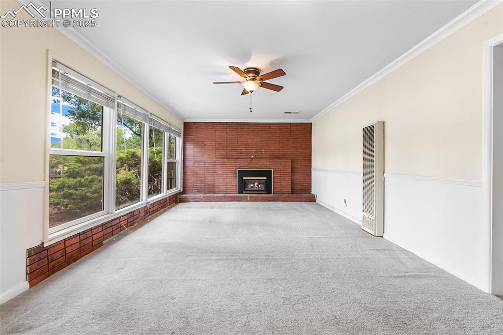 Image 19 of 41: Unfurnished living room featuring carpet floors, crown molding, a ceiling f