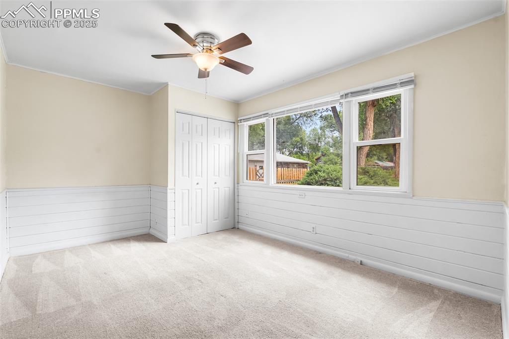 Image 21 of 41: Unfurnished bedroom featuring wainscoting, carpet floors, ornamental moldin