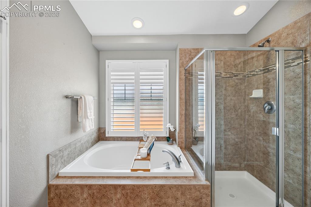 Image 26 of 40: Soaking tub and separate tiled shower in the Primary Bathroom.