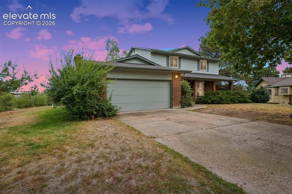 Image 2 of 40: Two-story exterior featuring a brick and siding facade, covered entryway, a