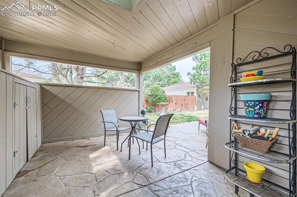 Image 27 of 31: Covered patio off of primary suite onto patos and lawn