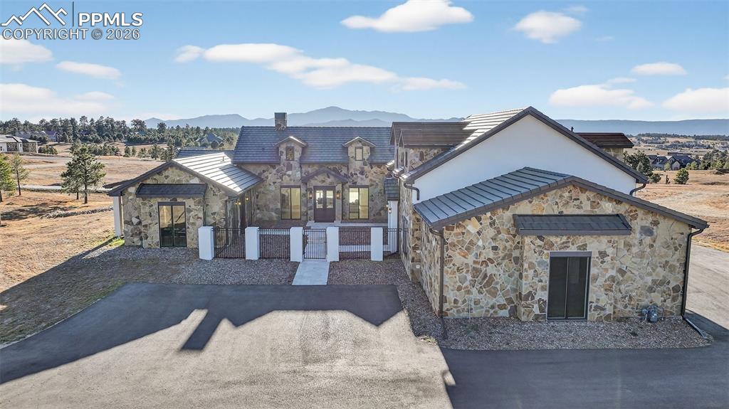 Image 1 of 49: View of front facade with stone siding and a mountain view