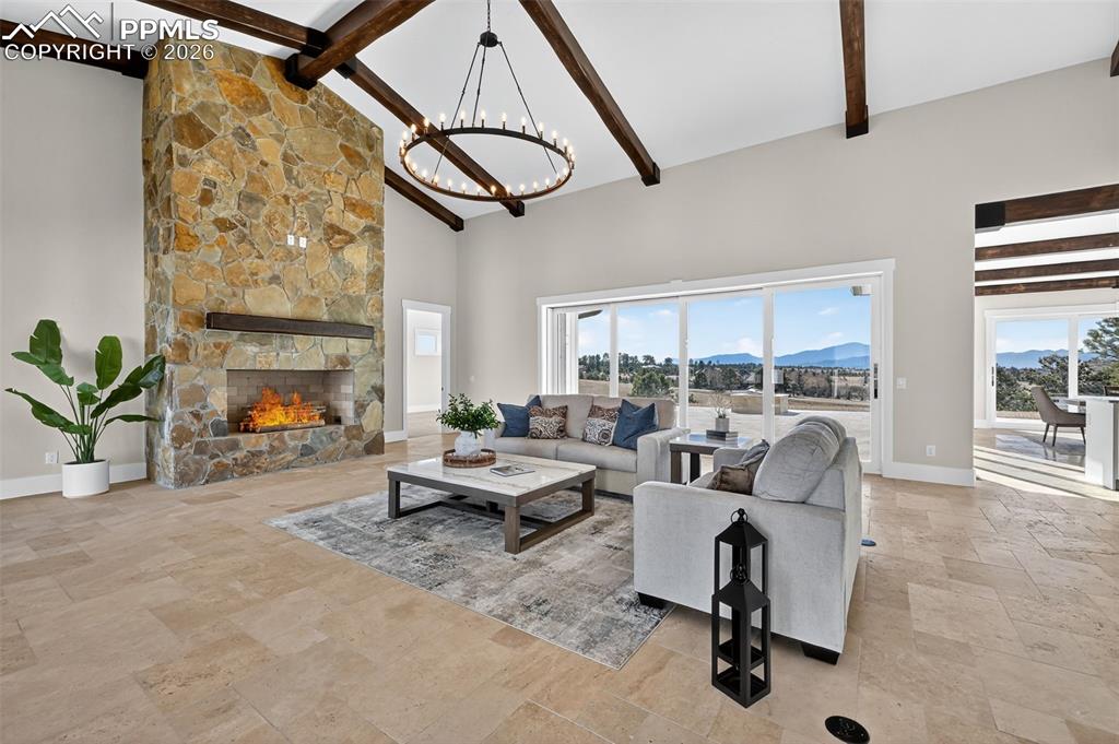 Image 21 of 49: Living room featuring a mountain view, stone tile floors, a stone fireplace