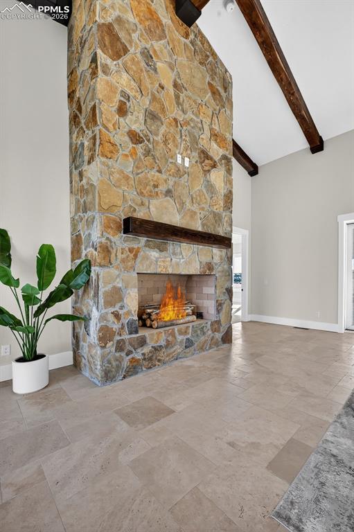 Image 22 of 49: Unfurnished living room featuring a stone fireplace, stone tile flooring, a