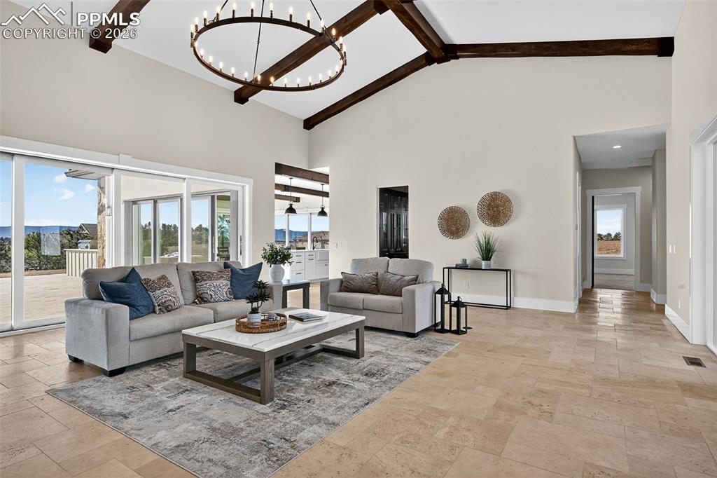 Image 25 of 49: Living area with hanging lights and light stone finish flooring