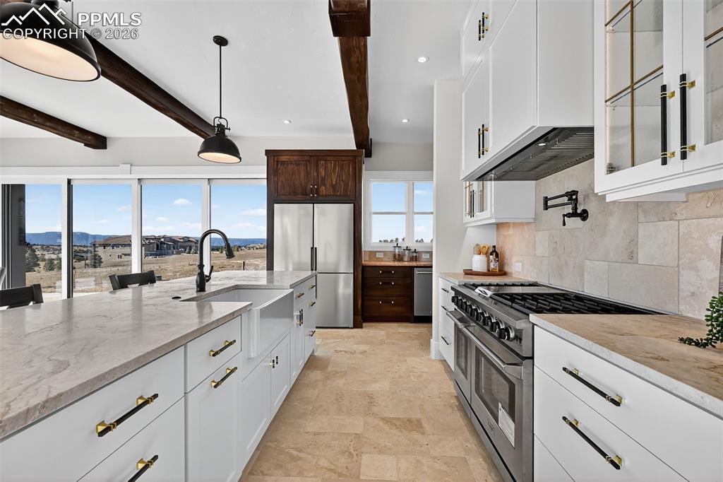 Image 30 of 49: Two tone kitchen with stainless steel appliances, light stone countertops,