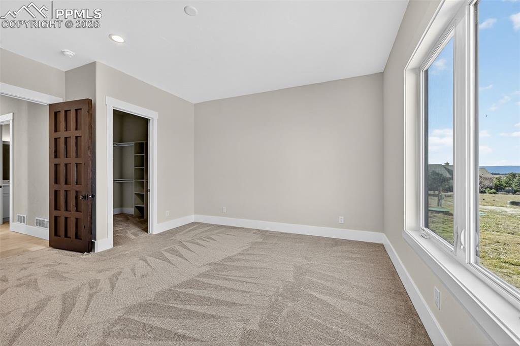 Image 39 of 49: Unfurnished bedroom featuring a spacious closet and light colored carpet