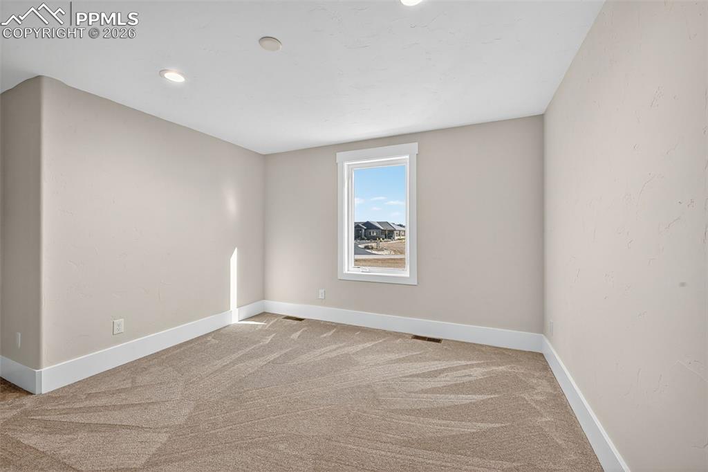 Image 44 of 49: Spare room featuring baseboards and light carpet