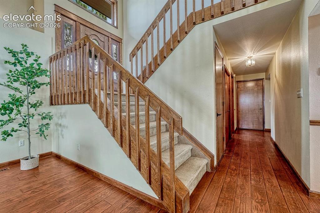 Image 12 of 50: Curved stair case to the upper and main levels of the home.