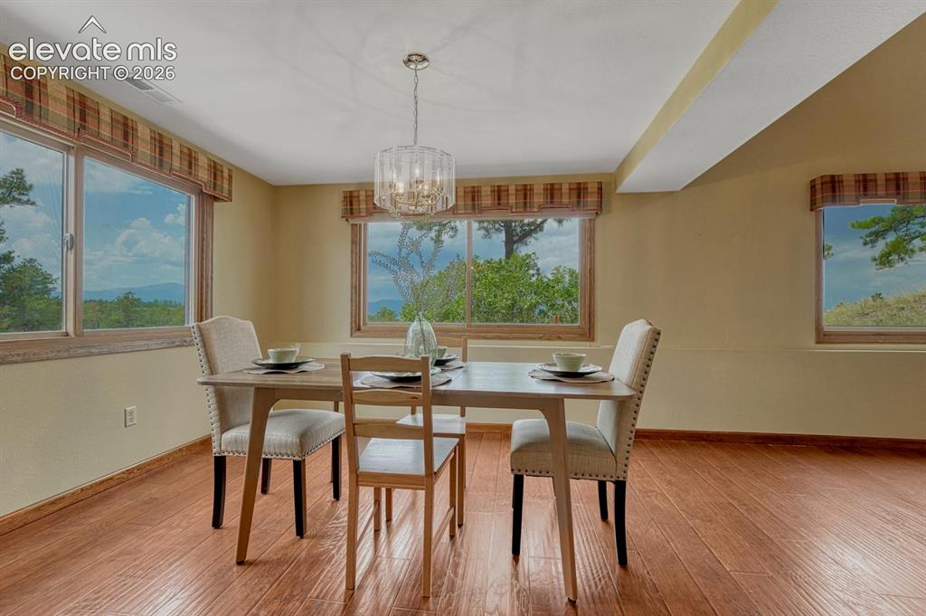 Image 15 of 50: The Formal Dining Room is surrounded by windows and fill the home with natu