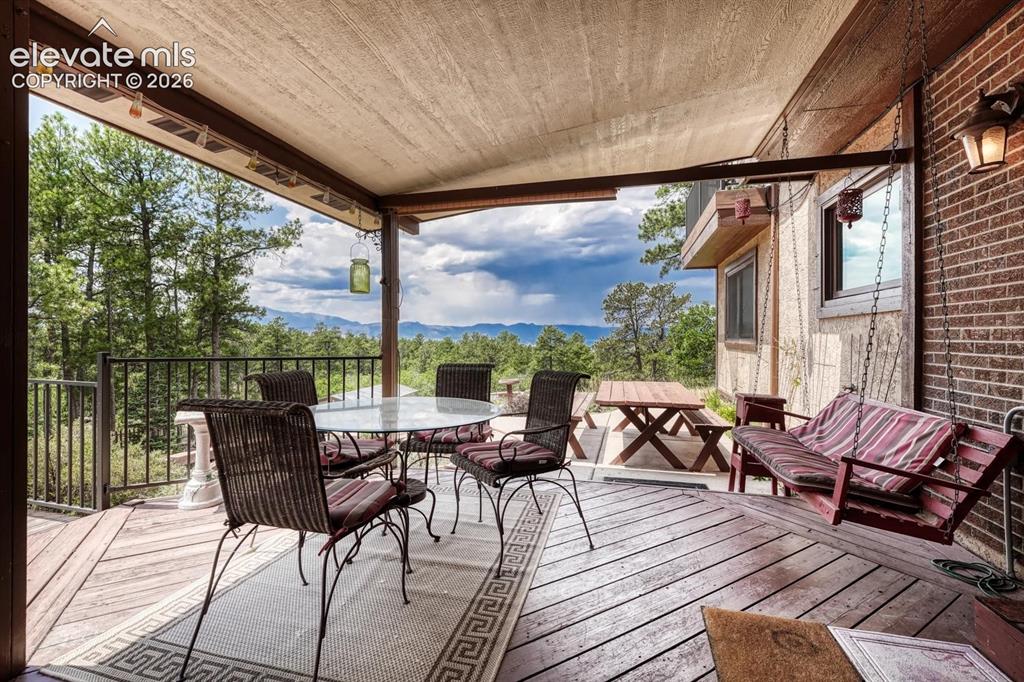 Image 18 of 50: Covered Trex deck and expanded concrete patio with fabulous mountain views.