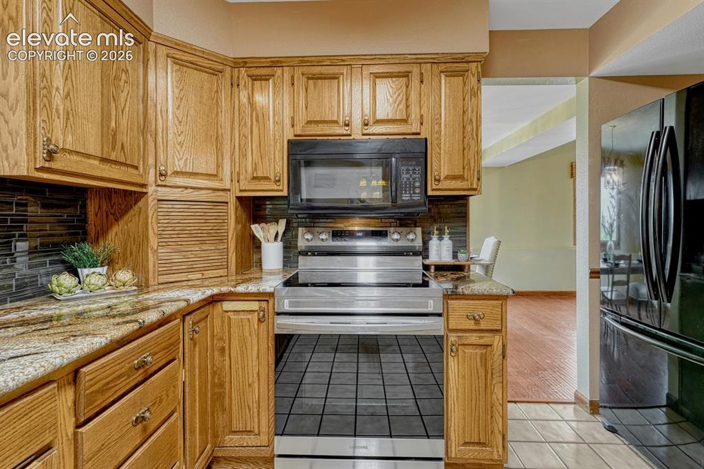 Image 21 of 50: Smooth top range oven and overhead microwave oven.