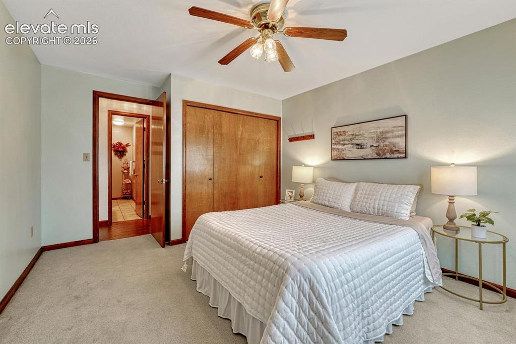 Image 28 of 50: Upper Level Bedroom with carpet and lighted ceiling fan.