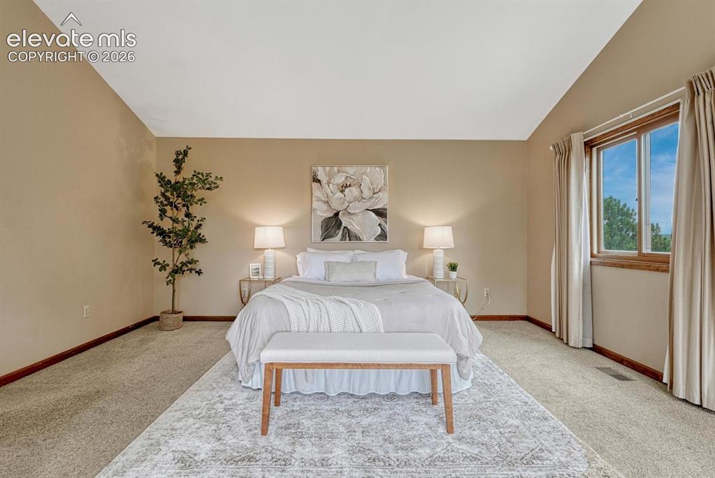 Image 31 of 50: The expansive primary suite offers speaker wiring, skylights, auto shades,