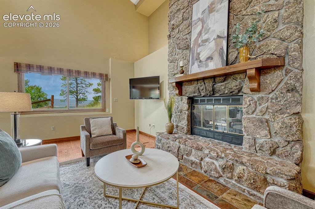Image 4 of 50: Spacious family room with LVP flooring, vaulted ceilings, and a floor-to-ce