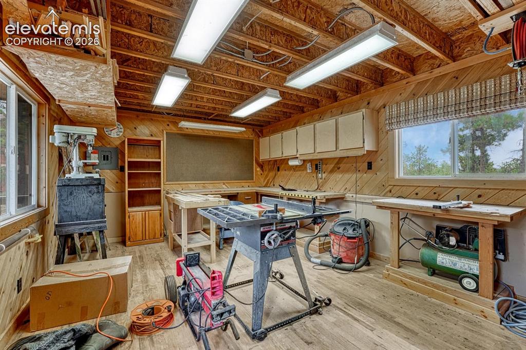 Image 47 of 50: Interior of powered workshop with oak floors and built-in cabinetry.