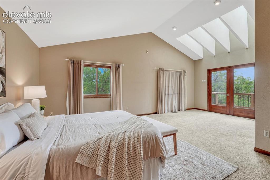 Image 7 of 50: The expansive primary suite has new skylights and French doors that open to