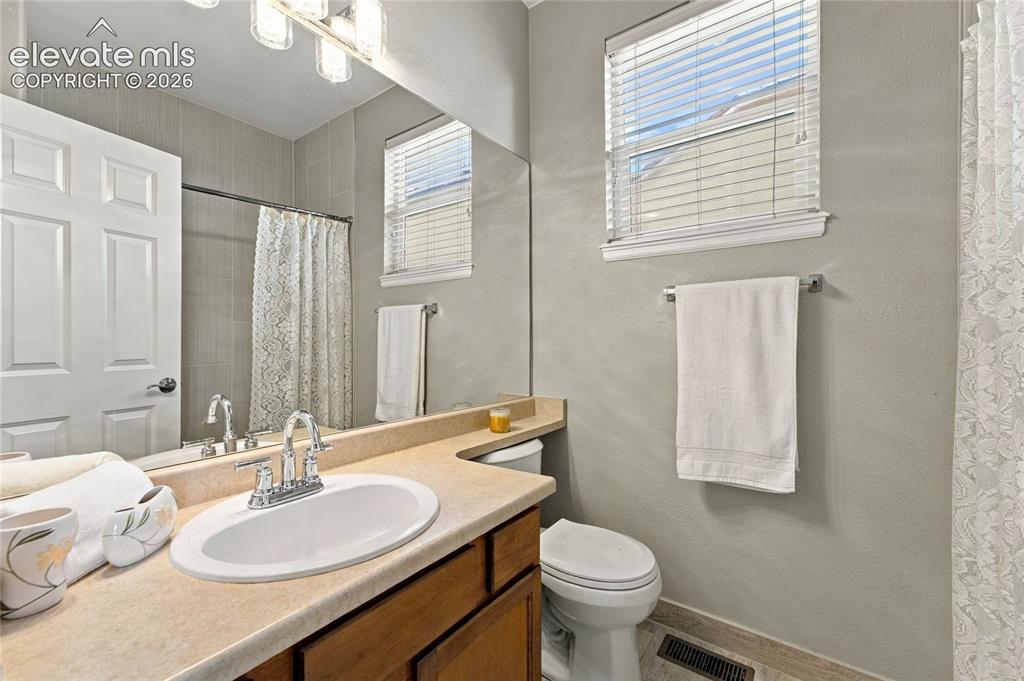 Image 14 of 24: main level secondary bath with new lighting and bath hardware
