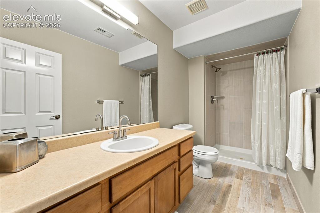 Image 19 of 24: basement bath with new light fixture, hardware and floor to ceiling shower 