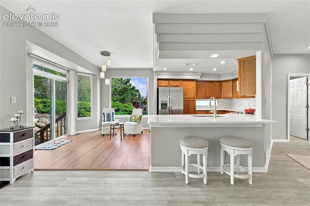 Image 6 of 25: open floorplan with breakfast counter and stainless kitchen appliances