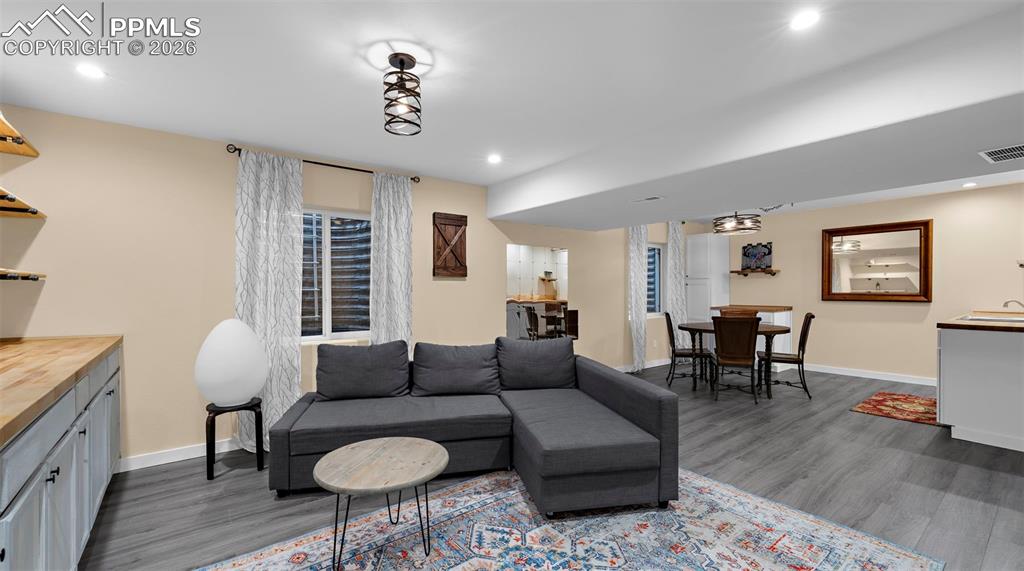 Image 24 of 43: Living room featuring dark wood-type flooring and recessed lighting