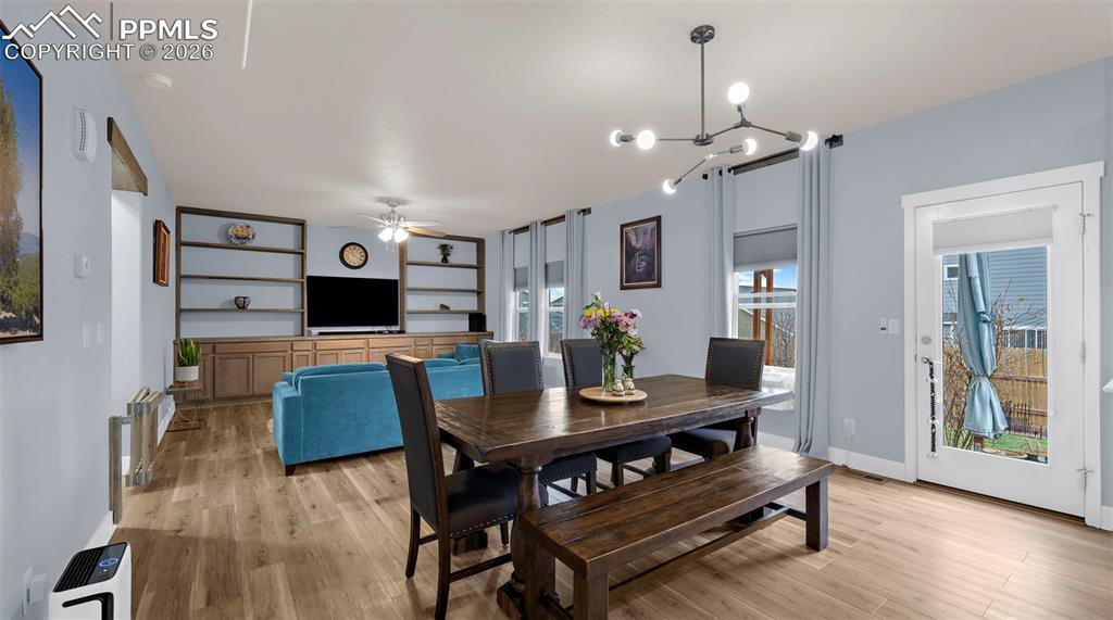 Image 8 of 43: Dining area featuring light wood-style floors, suspended lighting, and a ce